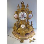 A late 19thC gilt metal cased mantel clock embellished with painted porcelain panels,