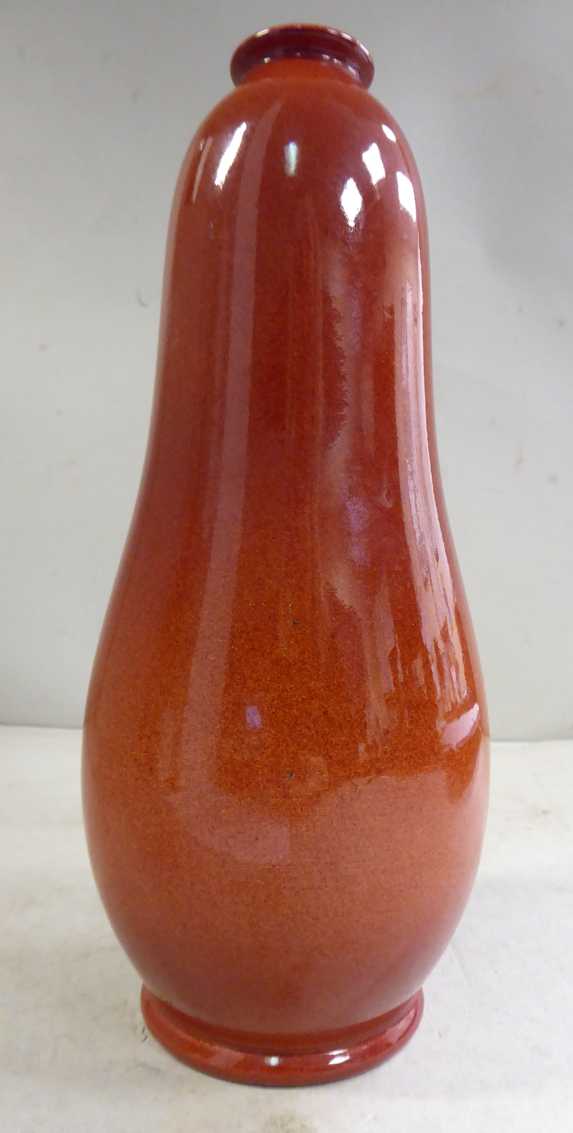 A Pilkingtons Royal Lancastrian sponged iron red glazed pottery vase of gourd form with a narrow