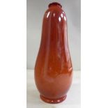 A Pilkingtons Royal Lancastrian sponged iron red glazed pottery vase of gourd form with a narrow