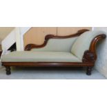 An early Victorian mahogany showwood framed chaise longue with C-scrolled and floral carved