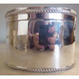 A silver oval biscuit box with straight sides,