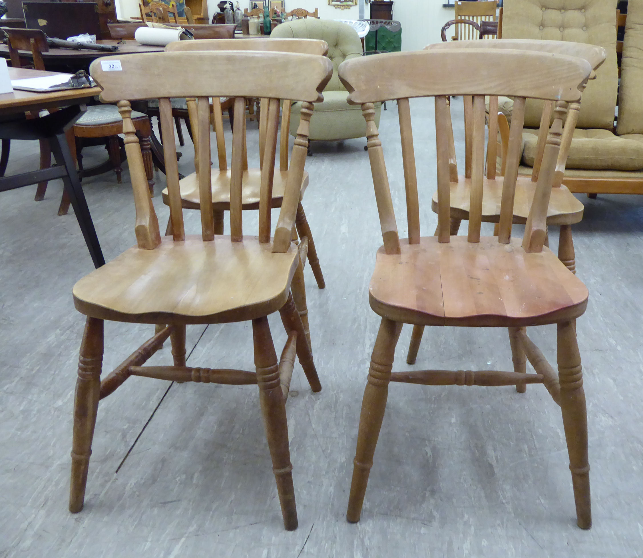 A set of four modern pine framed dining chairs with curved bar crests and lath backs,