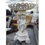 A mid 20thC china table centrepiece, the pierced shallow bowl, over three cherubs,