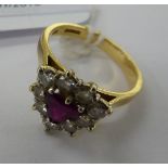 An 18ct gold ring with a heart shaped bezel and a central ruby,