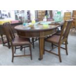 An early 20thC mahogany wind-out extending dining table, the top with round corners,