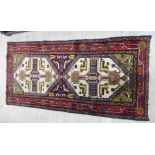 A Persian rug decorated with stylised designs on a multi-coloured ground 72'' x 35'' CB