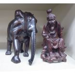 A 20thC Asian carved hardwood figure, a seated, robed man,