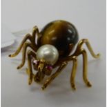 A gold coloured metal spider brooch,