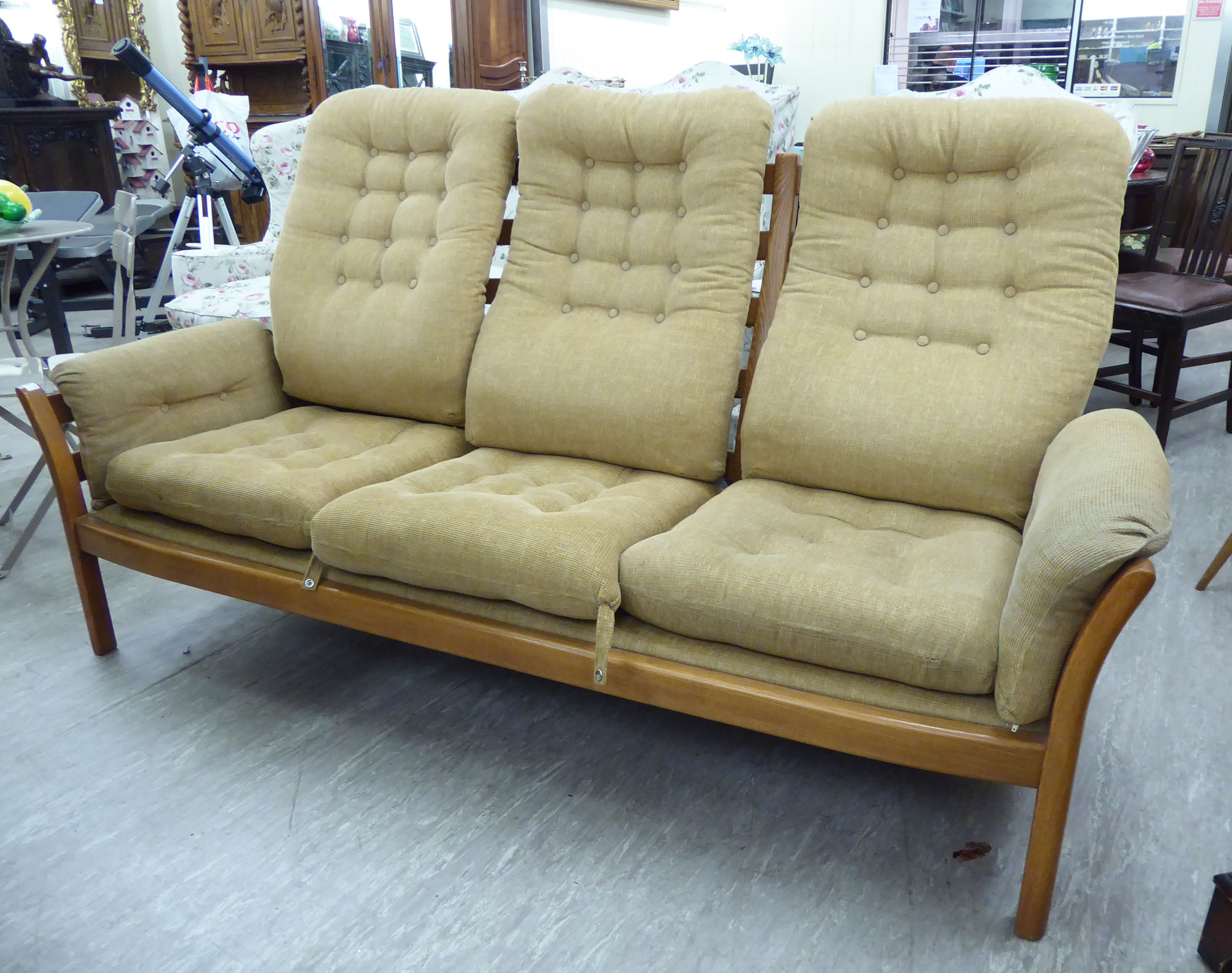 An Ercol light elm framed three person settee,