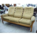 An Ercol light elm framed three person settee,