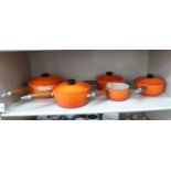 A graduated set of four Le Creuset burnt orange coloured enamelled cast iron saucepan with pouring