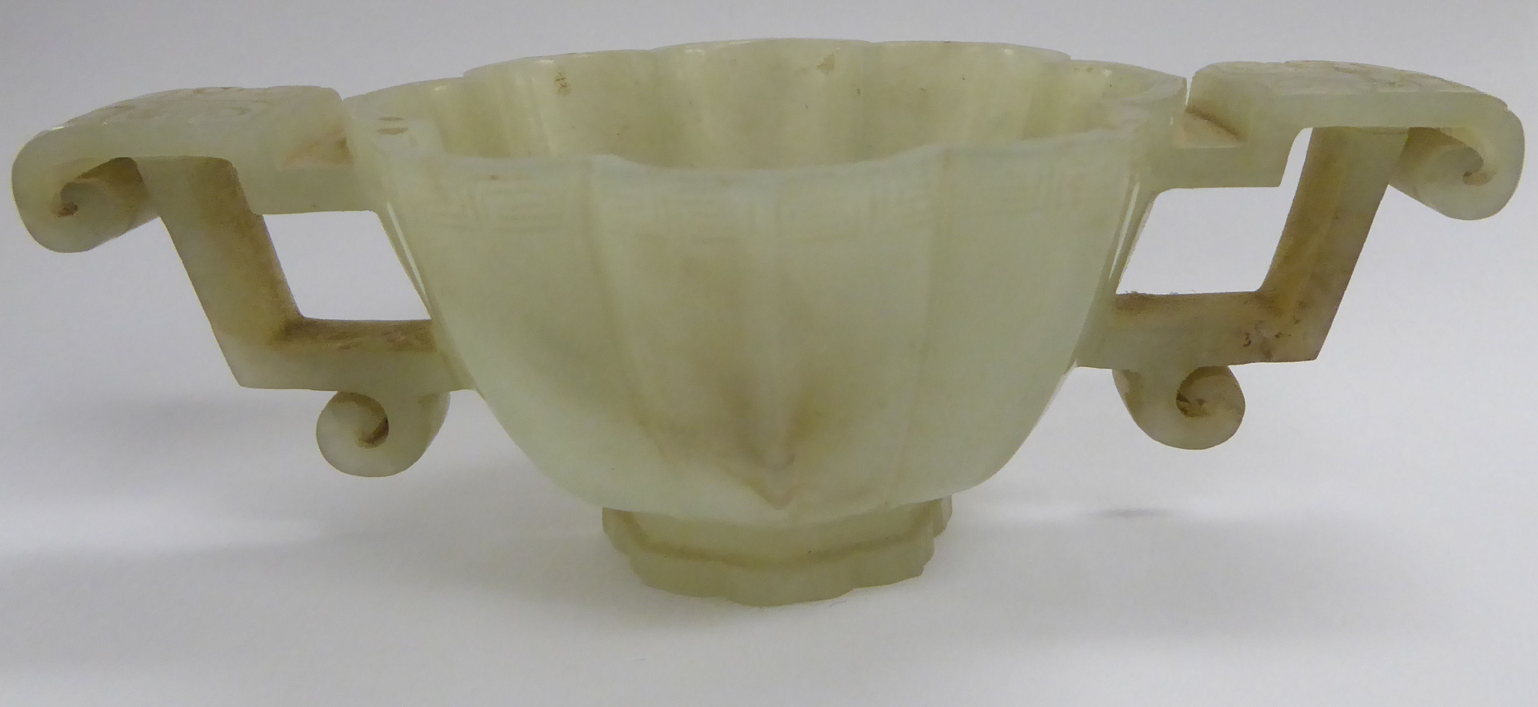 A modern carved jade libation cup with opposing C-scroll handles and engraved ornament 3''dia