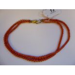 A two row coral bead necklace,