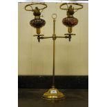 An early/mid 20thC brass framed, twin branch table lamp with clear and coloured glass reservoirs,