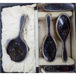 An Edwardian silver and tortoiseshell backed five piece dressing table set comprising a mirror,