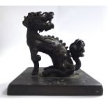 A late 19thC Chinese cast and patinated bronze model, a seated dragon-dog,