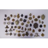 Approx fifty military cap badges, some copies: to include the XXIV Lancers,