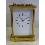 A 20thC lacquered brass cased carriage clock with bevelled glass panels and a folding top handle,