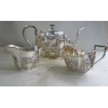 An Edwardian three piece silver tea set of panelled, oval form,