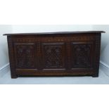 An 18thC panelled oak coffer with straight sides, a profusely carved front and hinged lid,