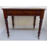 A late Victorian mahogany writing table, the top with round corners and a tooled,