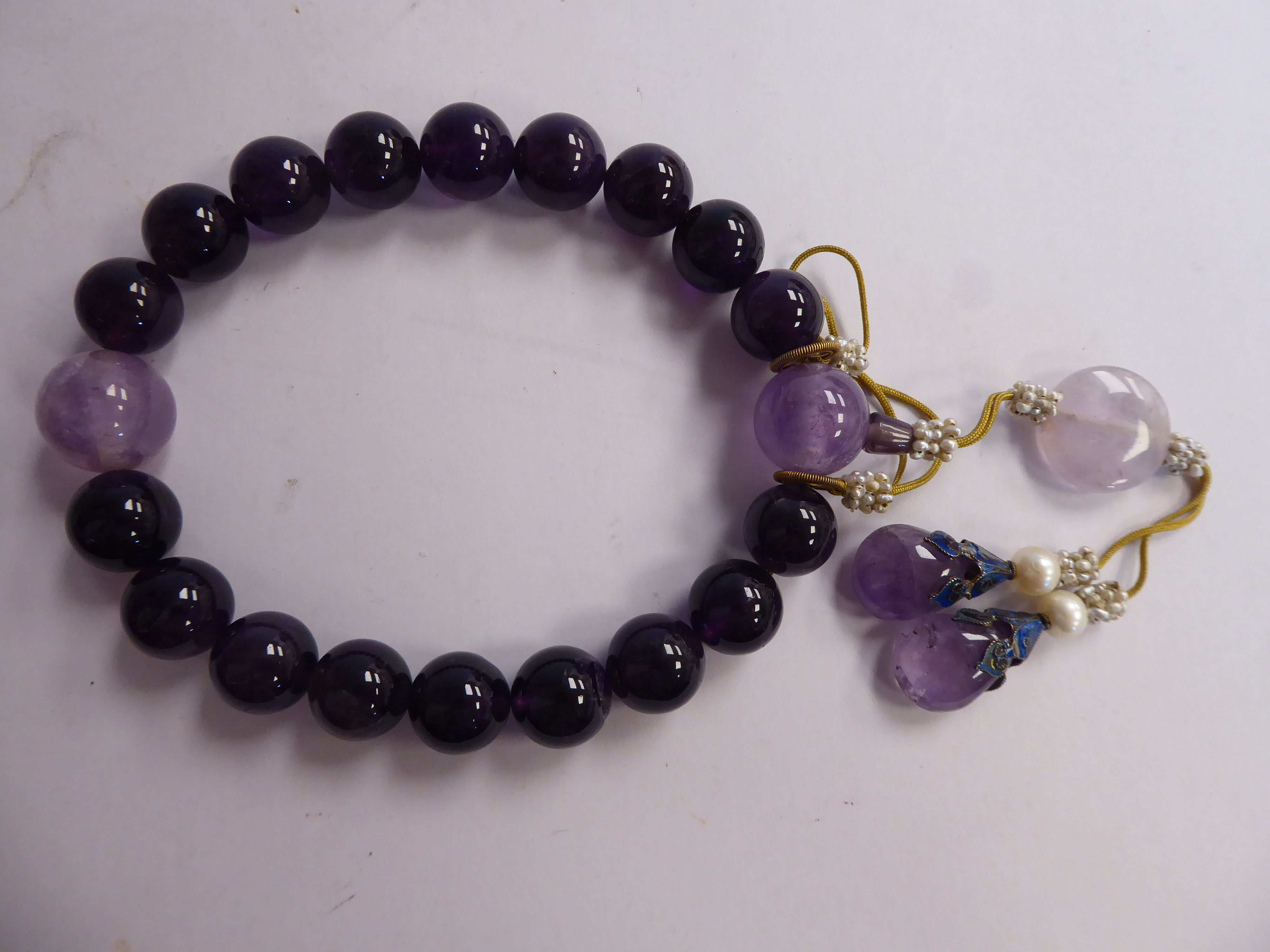 A Chinese amethyst coloured stone and seed pearl bead bracelet with pendants