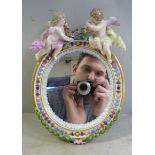 A late 19th/early 20thC Meissen porcelain framed oval mirror with decoratively moulded laurel leaf