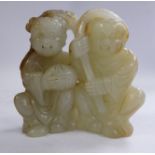 A mid/late 19thC Chinese carved pale green and brown jade group, two seated figures,