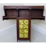 An Arts & Crafts mahogany T-shaped hanging shelf unit, comprising an open galleried top,