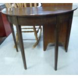 An early 20thC mahogany demi-lune console table with a straight apron, raised on square,