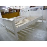 A modern white painted single bed frame,