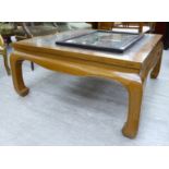 A modern Chinese lacquered elm coffee table, the openwork top with a glass panel, raised on carved,