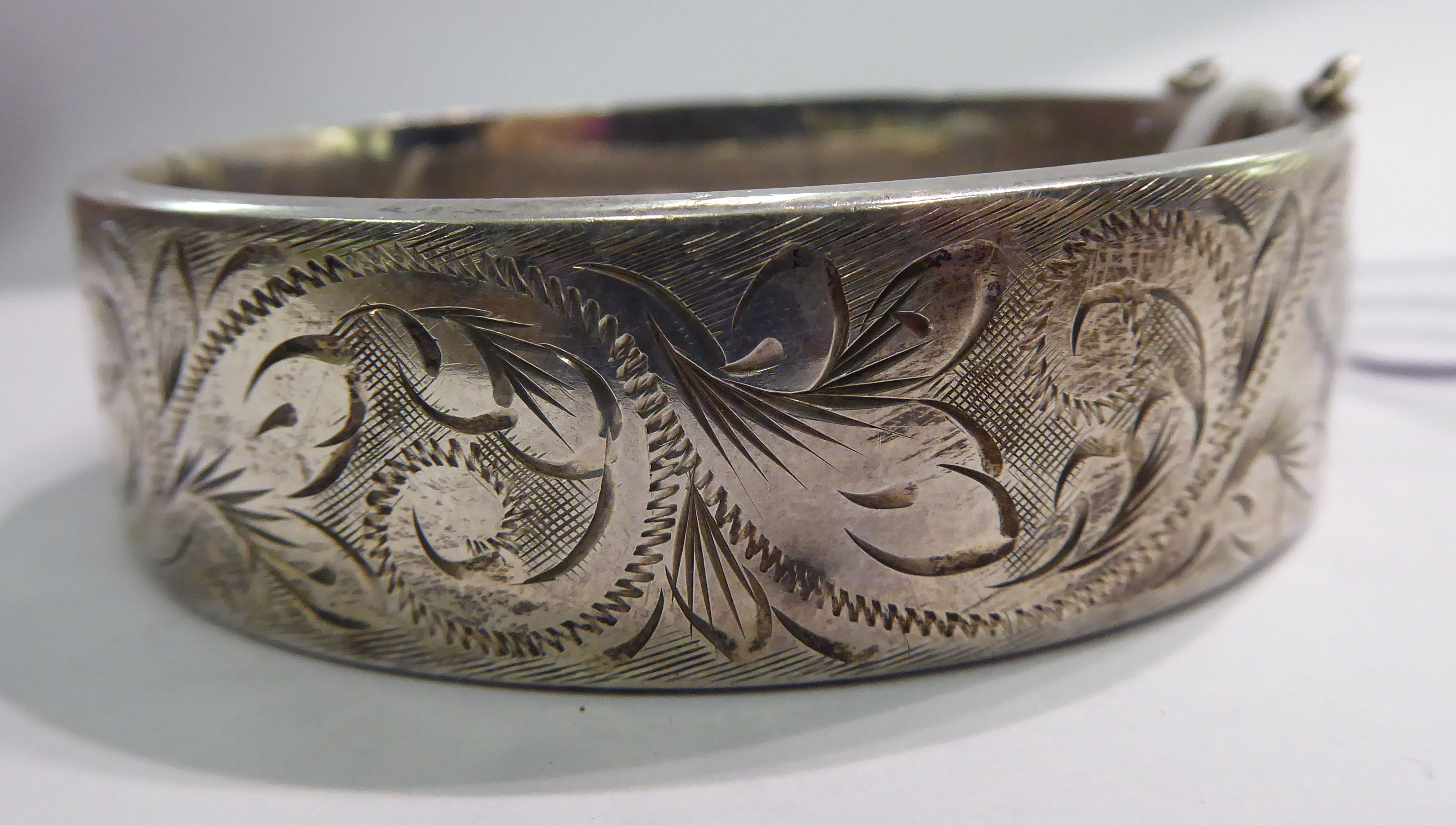 A silver hollow bangle with engraved foliate ornament Birmingham 1974 11