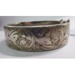 A silver hollow bangle with engraved foliate ornament Birmingham 1974 11