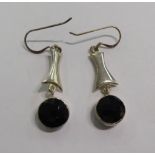 A pair of white metal earrings,