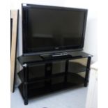 A Sony Bravia 32'' television and remote control with a contemporary blackened glass,