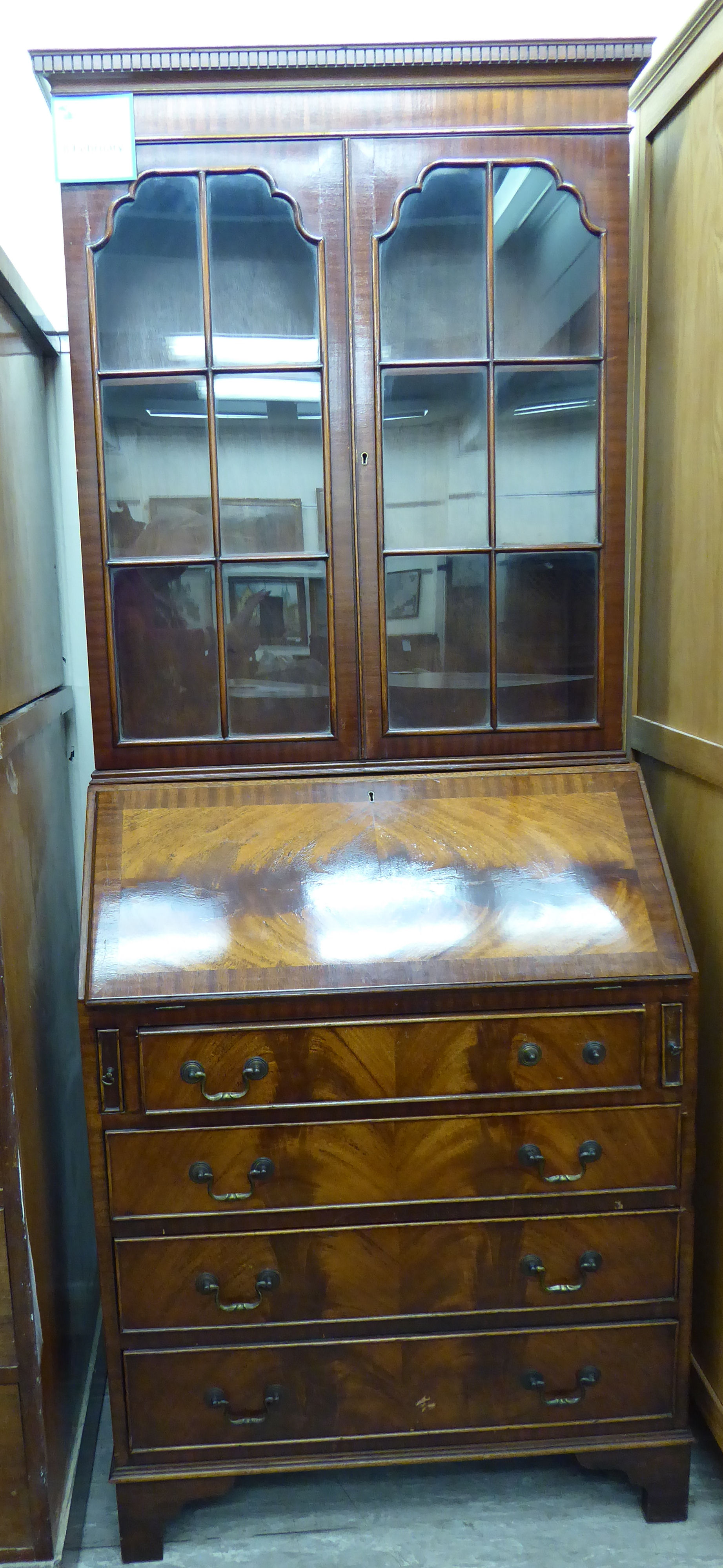 A modern Georgian style mahogany bureau bookcase with a dentil moulded cornice,