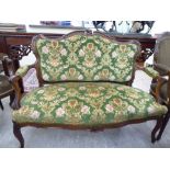 A late Victorian style mahogany showwood framed two person, open arm salon settee,