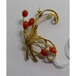 A gold coloured metal scrolled wire brooch,