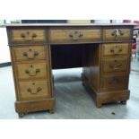 An early 20thC oak nine drawer twin pedestal desk,