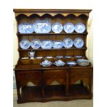 A modern stained oak dresser, the superstructure with a thumb moulded cornice,