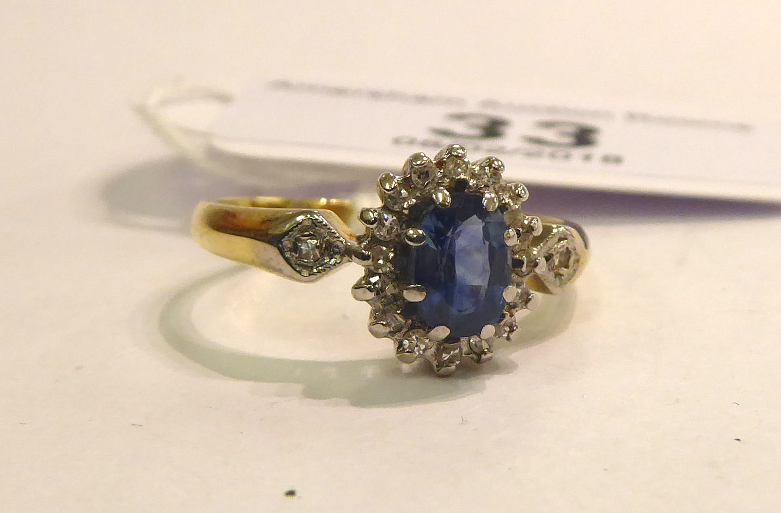 An 18ct gold claw set sapphire and diamond cluster ring 11