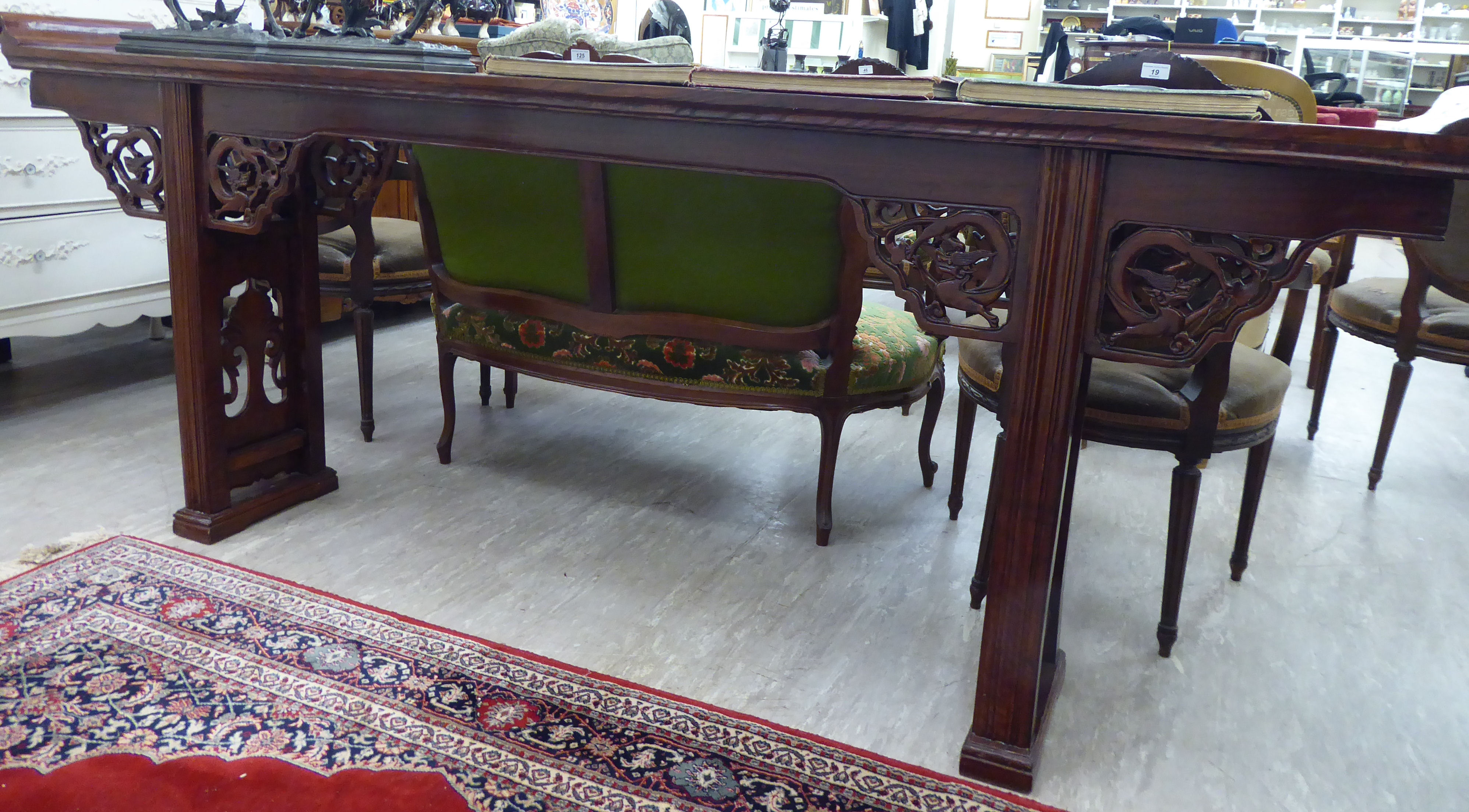 A modern Chinese lacquered elm altar table, the top with raised ends, over a carved apron,