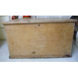 An early 20thC waxed boarded pine chest with straight sides and a hinged lid,