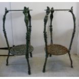 A pair of early 20thC cast and patinated iron two tier torchere stands, raised on splayed,