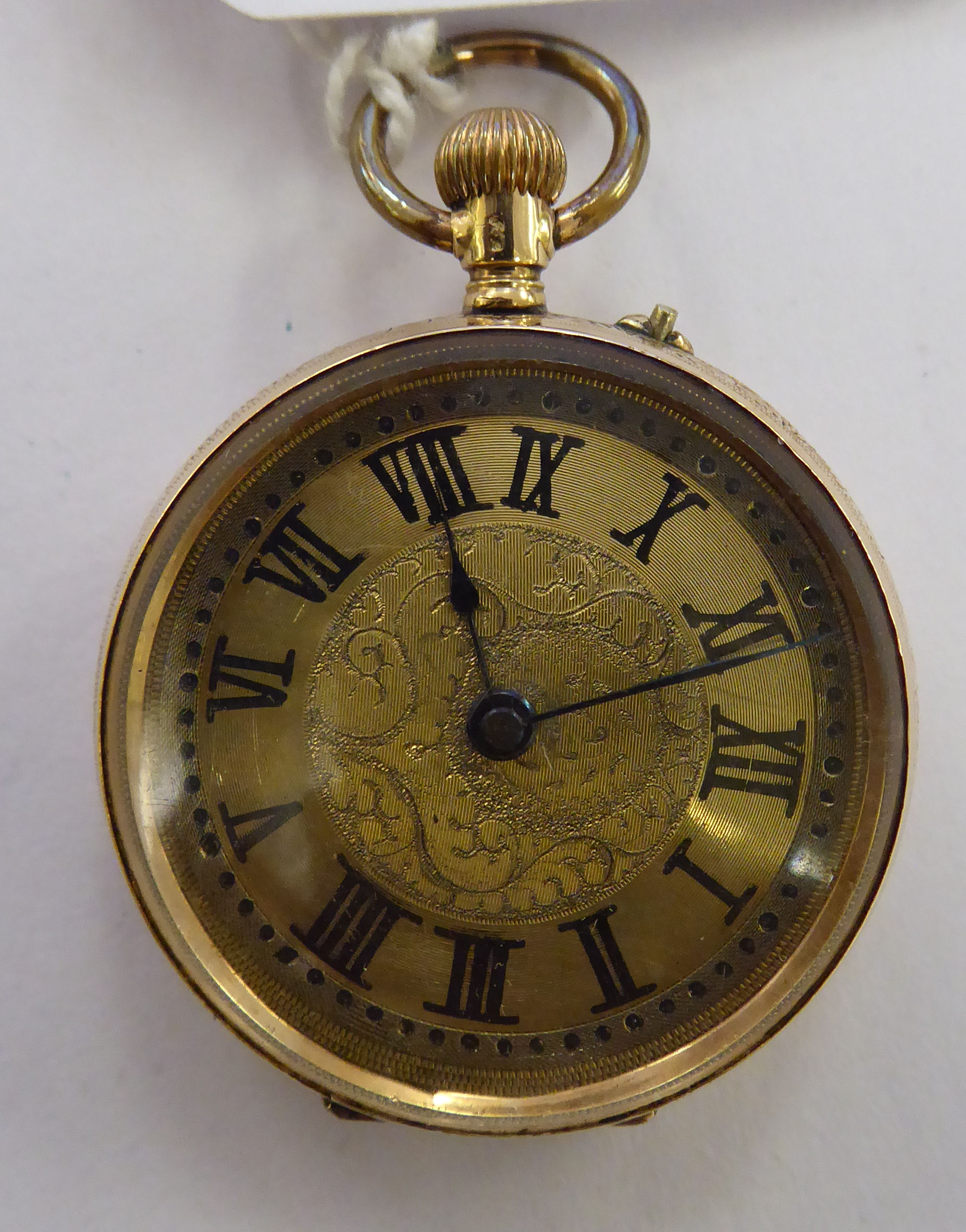 A lady's gold coloured metal cased fob watch with engraved ornament,