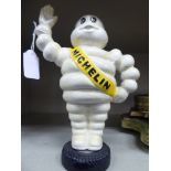 A cast iron 'Michelin Man' standing on a tyre 9''h OS4