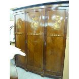 A 1930/50s mahogany bow front wardrobe, enclosing an arrangement of shelves and rails,