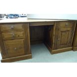 A modern honey coloured pine desk, raised on twin pedestals and straight plinths,