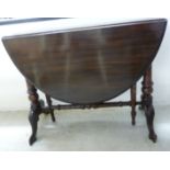A late Victorian stained and carved walnut Sutherland table with an oval top,